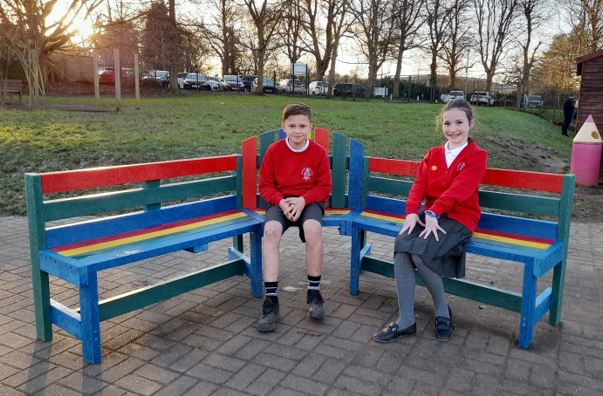 A child and child sitting on a bench

Description automatically generated