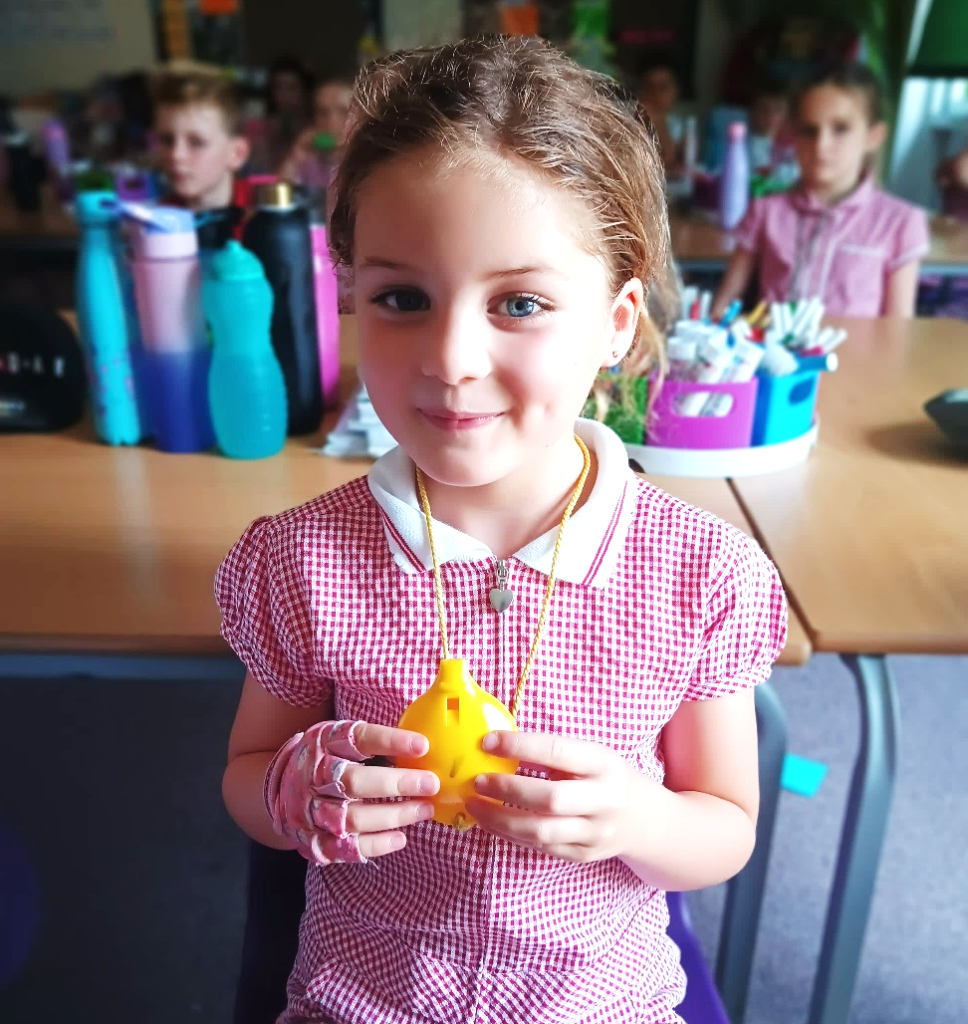 A child holding a yellow object Description automatically generated