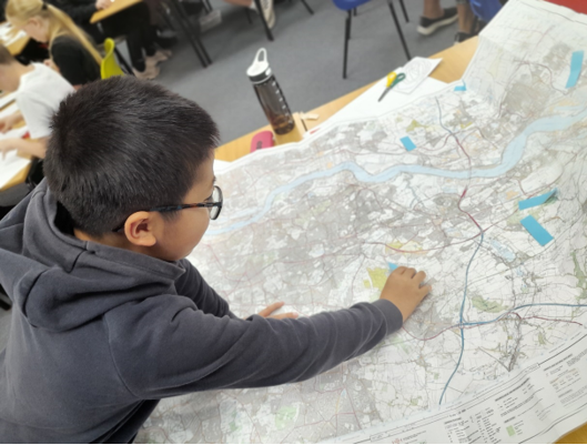 A child looking at a map

Description automatically generated