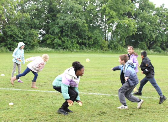 A group of children playing with a ball

Description automatically generated