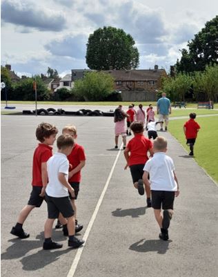 A group of children running on a road

Description automatically generated