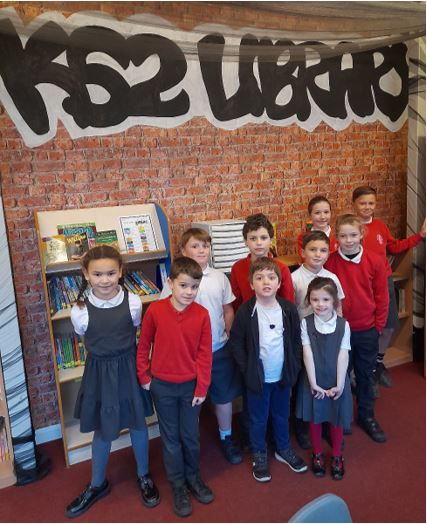 A group of children standing in front of a brick wall

Description automatically generated