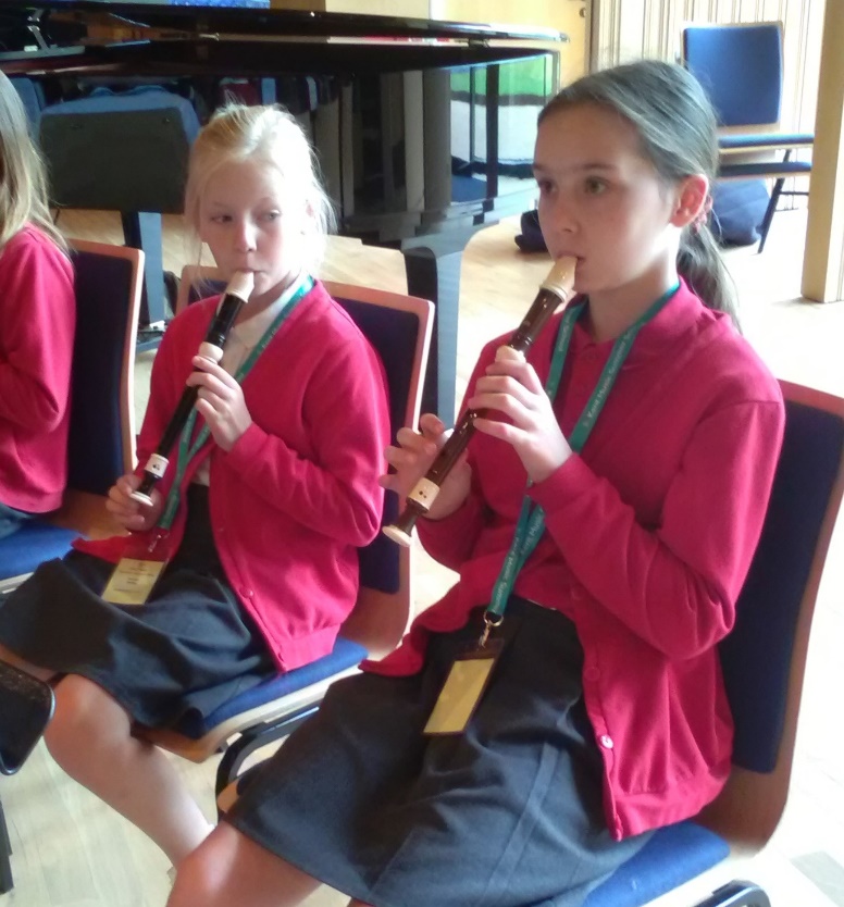 A group of girls playing flutes

Description automatically generated