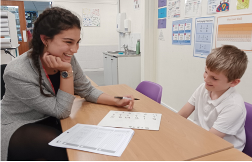 A person and a child sitting at a table

Description automatically generated