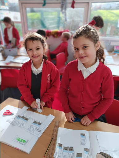 Two girls in red uniforms in a classroom

Description automatically generated